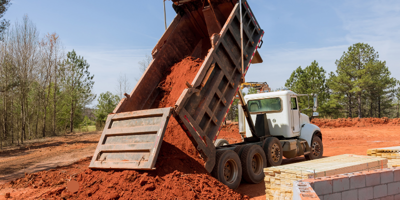 truck dumping aggregated material in Clewiston, florida